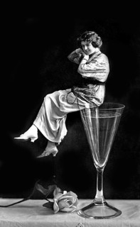 Woman sitting on a champagne glass