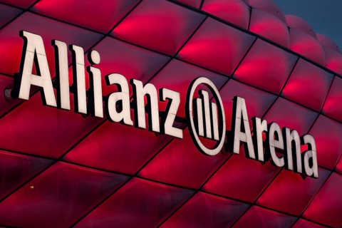 Red illuminated Allianz Arena with lettering