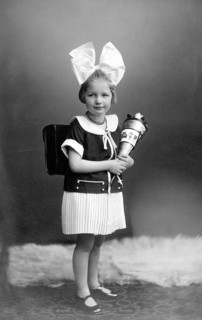 Girl with school bag and big hair bow ca. 1926