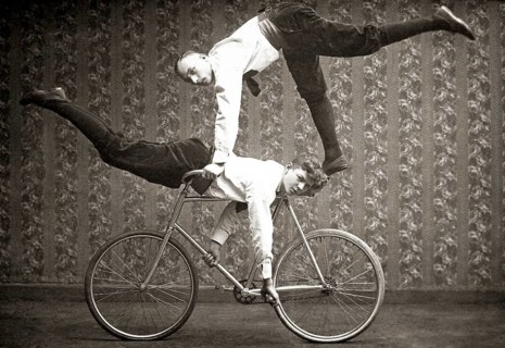 Two acrobats by bicycle