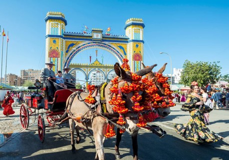 Decorated carriage with donkeys in front of lighted entrance gate