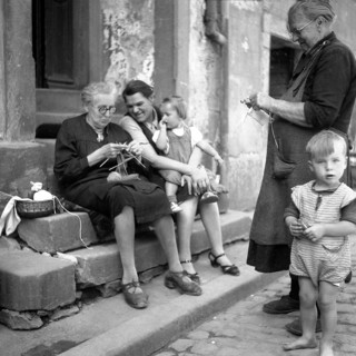 Mother and children shy away from the grandparents while knitting