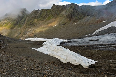 Covering of glacier ice with white plastic fleece to reduce glacier shrinkage in summer