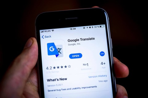 Hand holding iPhone with Google Translate App in the Apple App Store