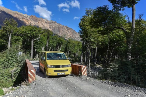 Yellow travel minibus on road to Lago del Desierto at Rio de las Vueltas
