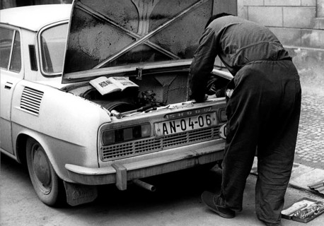 Man repairing car after instruction ca. 1970s