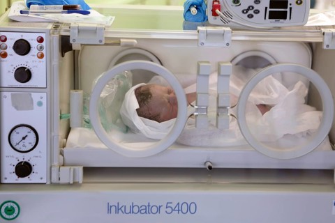 Newborn lying in incubator