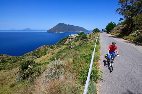 Cyclist at Punta del Legno Nero at Quattropani overlooking the island of Salina