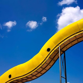Yellow slide in front of blue sky