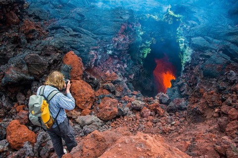 Tourist photographing an active magma stream below the Tolbachik volcano