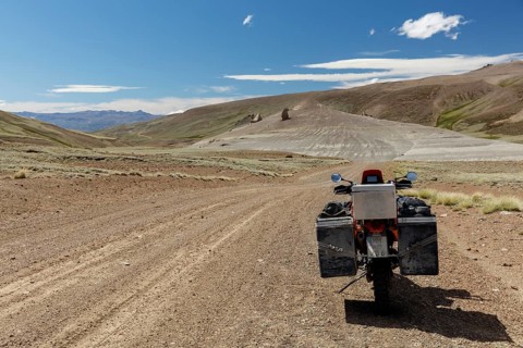 Heavily packed motorcycle on a gravel road in the desert