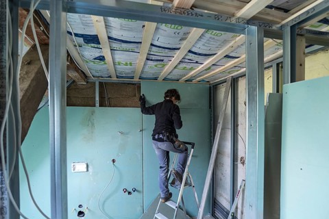 Young woman renovating the attic in an old house