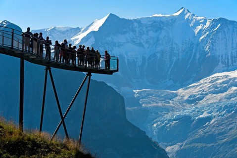 Tourists on the observation deck of the First Cliff Walk by Tissot in front of the Fiescherhorn north face and the Grindelwald glacier