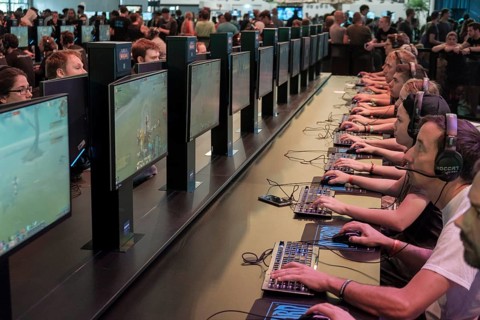 Visitors playing the computer game World of Warcraft in front of screens