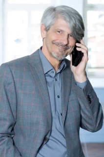 Man with mobile phone in front of his office window