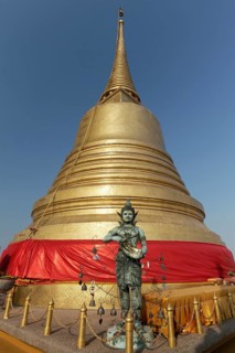 Bronze figure in front of the Golden Chedi on Phu Khao Thong