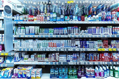 Toothpaste and toothbrushes in a supermarket shelf