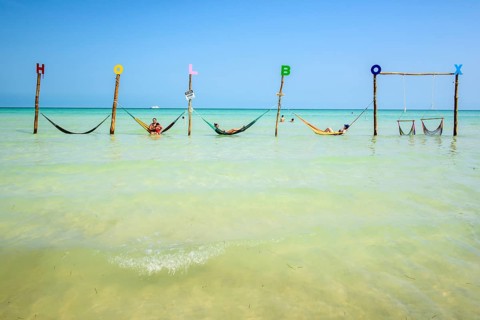 Tourists in hammocks on a beach
