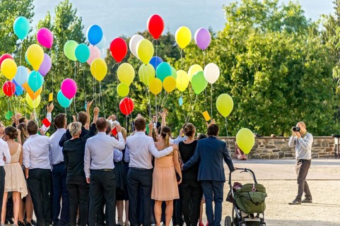Photographer takes photos of a festive gathering with colourful balloons