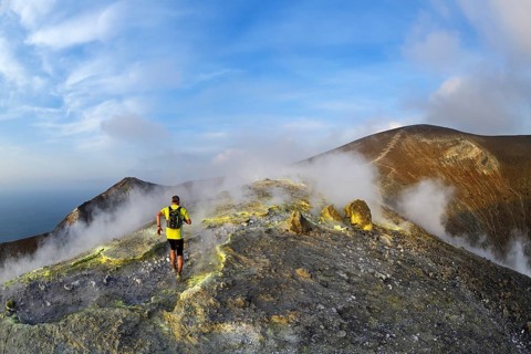 Trailrunner surrounded by sulfur fumaroles and chloride crusts on the crater rim