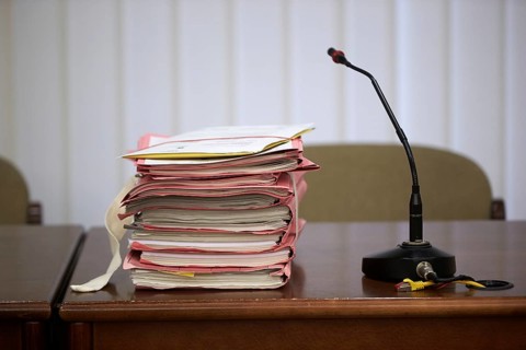 Trial files are on a judge's table in the courtroom