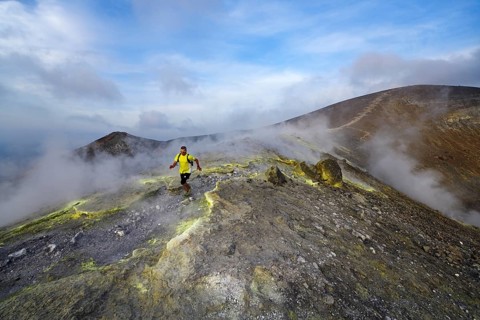 Trailrunner surrounded by sulfur fumaroles and chloride crusts on the crater rim