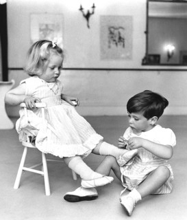 Boy ties up girls shoes