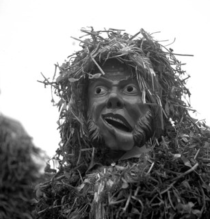 Masked man with drooping corner of his mouth and a suit of straw