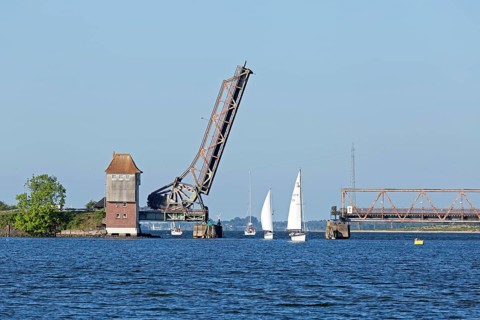 Sailboats sailing through open Schlei bridge