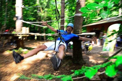 Man in the zipline from the forest adventure center and climbing forest Riegling