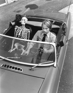Skeleton and man driving car