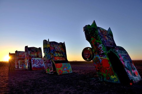 Sunset behind painted Cadillacs