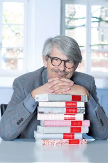 Man leaning on a book pile
