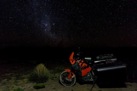 Heavily packed motorcycle on the plateau in front of the starry sky