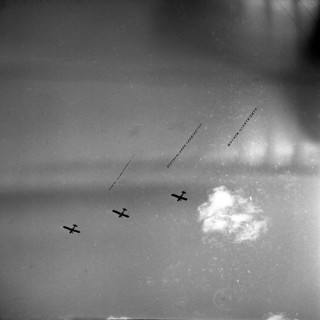 Three airplanes with banner fly synchronously