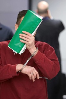 Defendant enters the courtroom in handcuffs