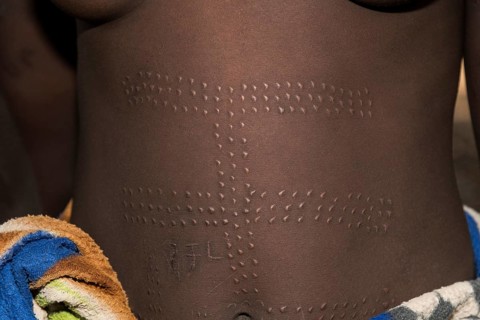 Young woman with ornamental scars on the belly