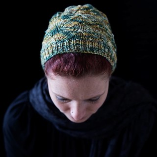 Woman with lowered head and green wool hat