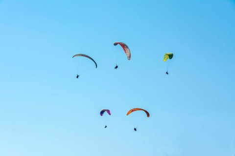 Paragliders in a blue sky