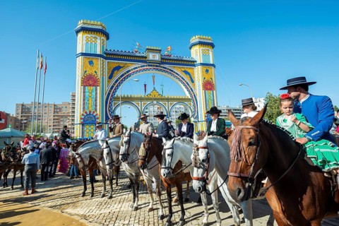 Rider on decorated horses with traditional clothes in front of lighted entrance gate