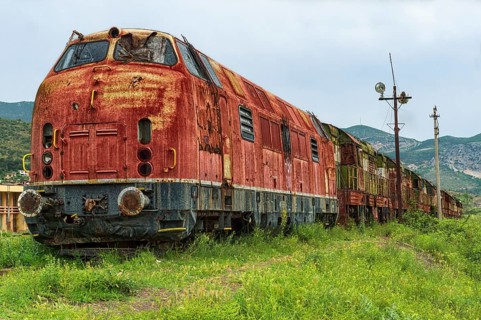 Decayed locomotive and train at former railway station