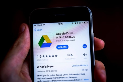 Hand holding an iPhone displaying Google Drive app