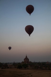 Hot air balloons at sunrise over temples and pagodas
