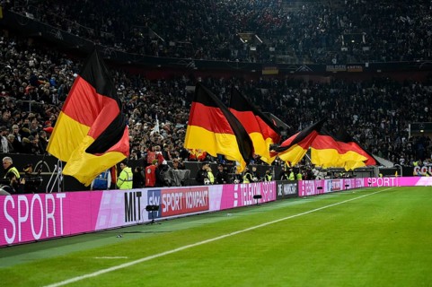 Atmospheric flag wavers with German flag in front of the start of the football match