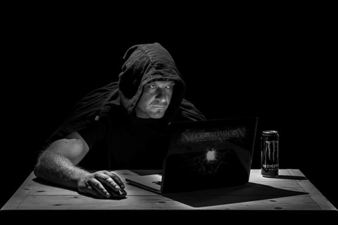 Man is sitting at the table in a dark room