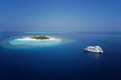Diving safari ship MS Keana anchors off uninhabited palm island