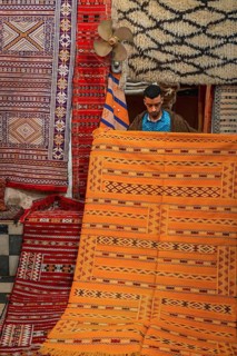 Carpet dealer shows a Moroccan carpet