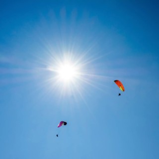 Paragliders in a blue sky