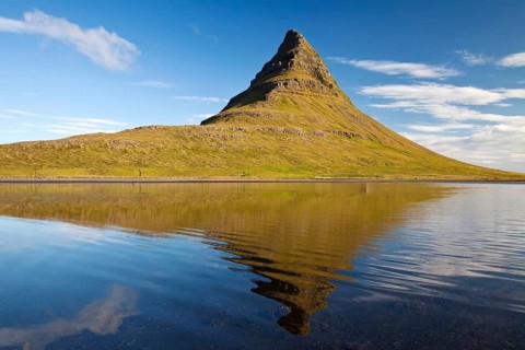 Mount Kirkjufell with water reflection in the fjord Grundarfjordur