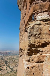 Local guide climbs to the entrance Abuna Yemata monolithic church in the Gheralta Mountains near Hawzen